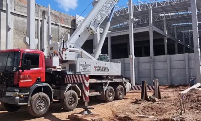 Operador certificado da Freire Guindastes conduzindo guindaste em obra com segurança